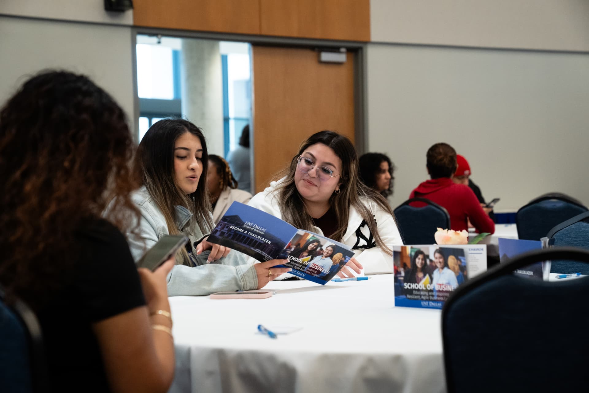 Students exploring School of Business materials at The Gold Chair