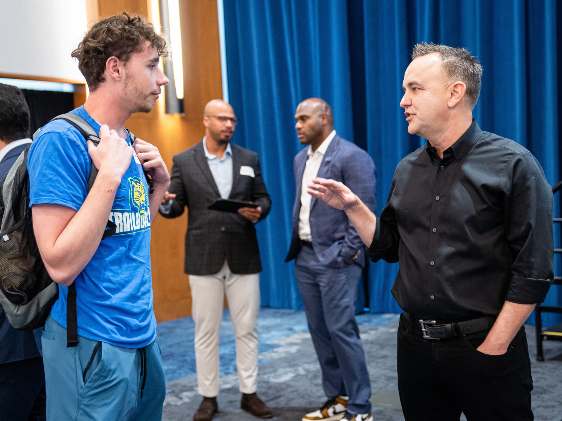 A UNT Dallas student speaking with a guest at The Gold Chair