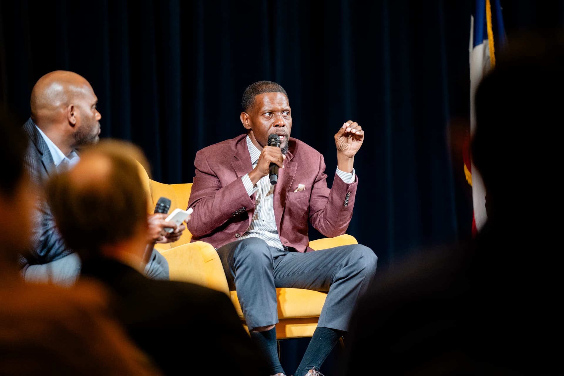 A guest speaker answering questions from the gold chair